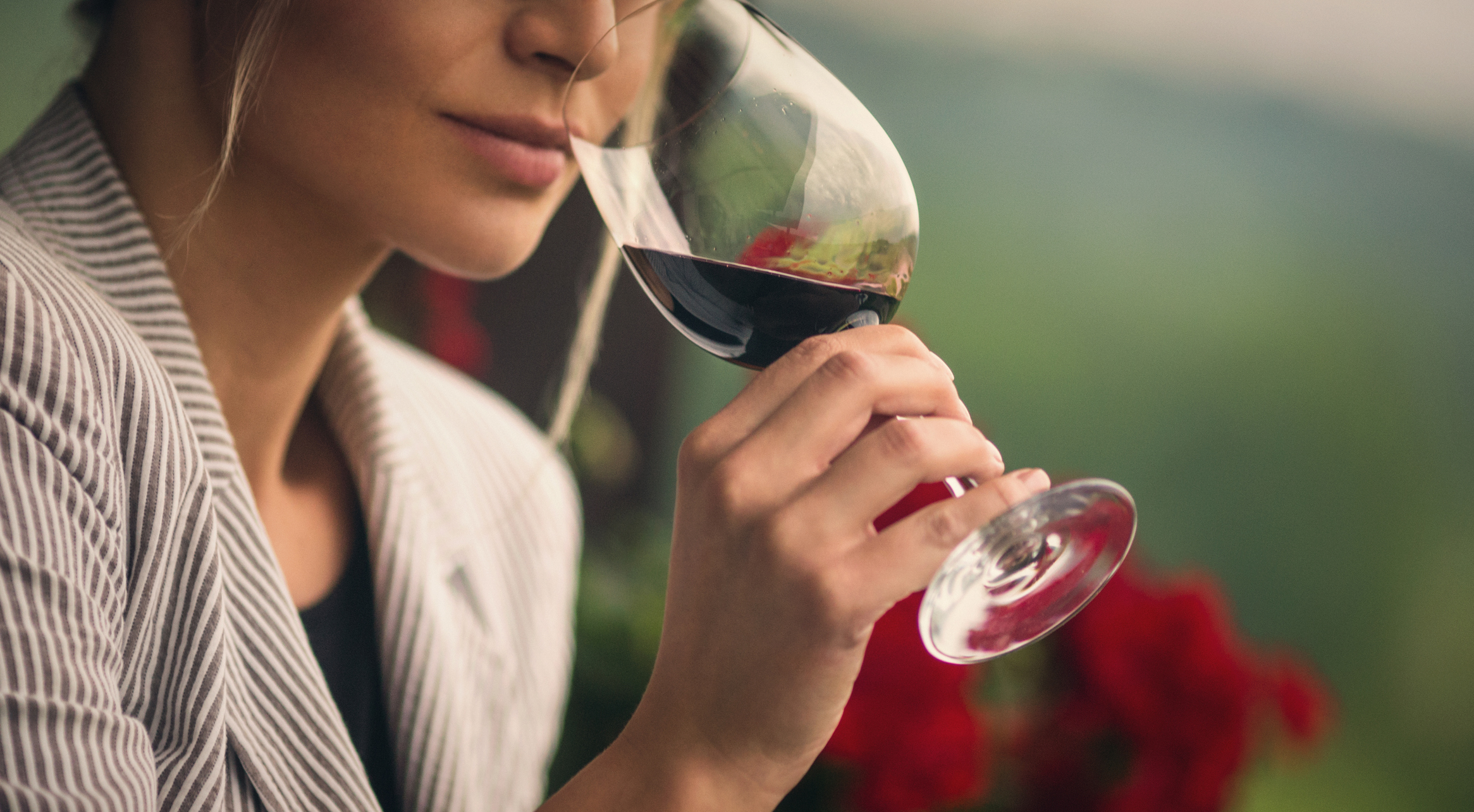 Woman tasting red wine.